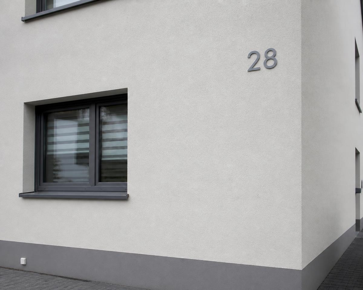Frisch beschichtete Hausfassade mit feiner Putzstruktur und sauberen Fensterlaibungen